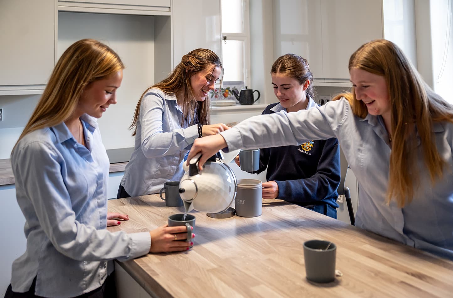 Girls making tea in the boarding house kitchen at Rugby School