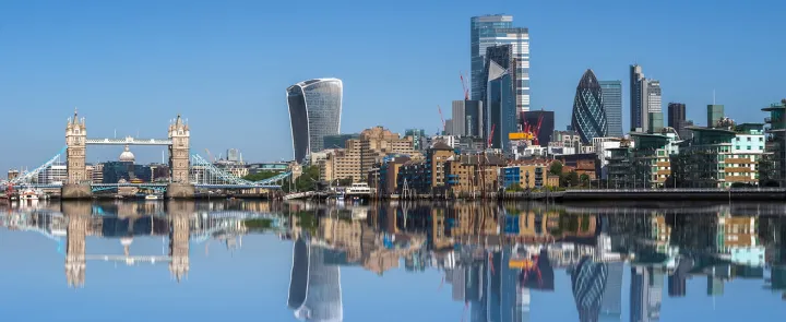 The London Skyline with Tower Bridge and the City of London reflected in the water of the river Thames